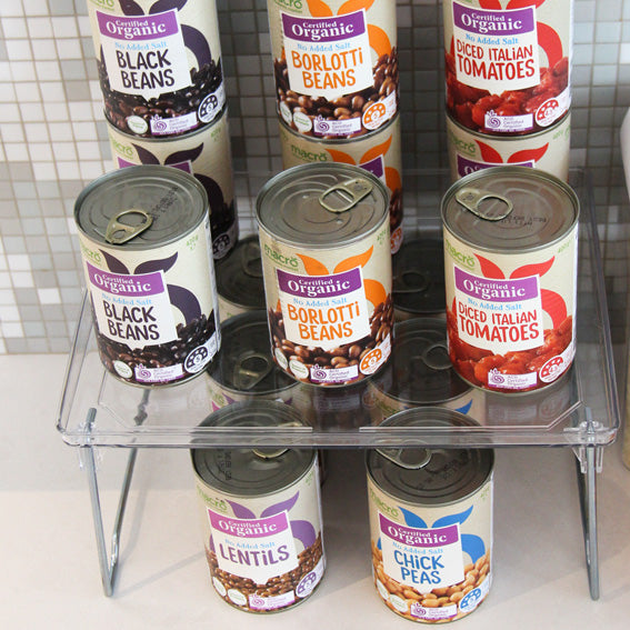 Clear plastic elevated storage rack holding several cans of food