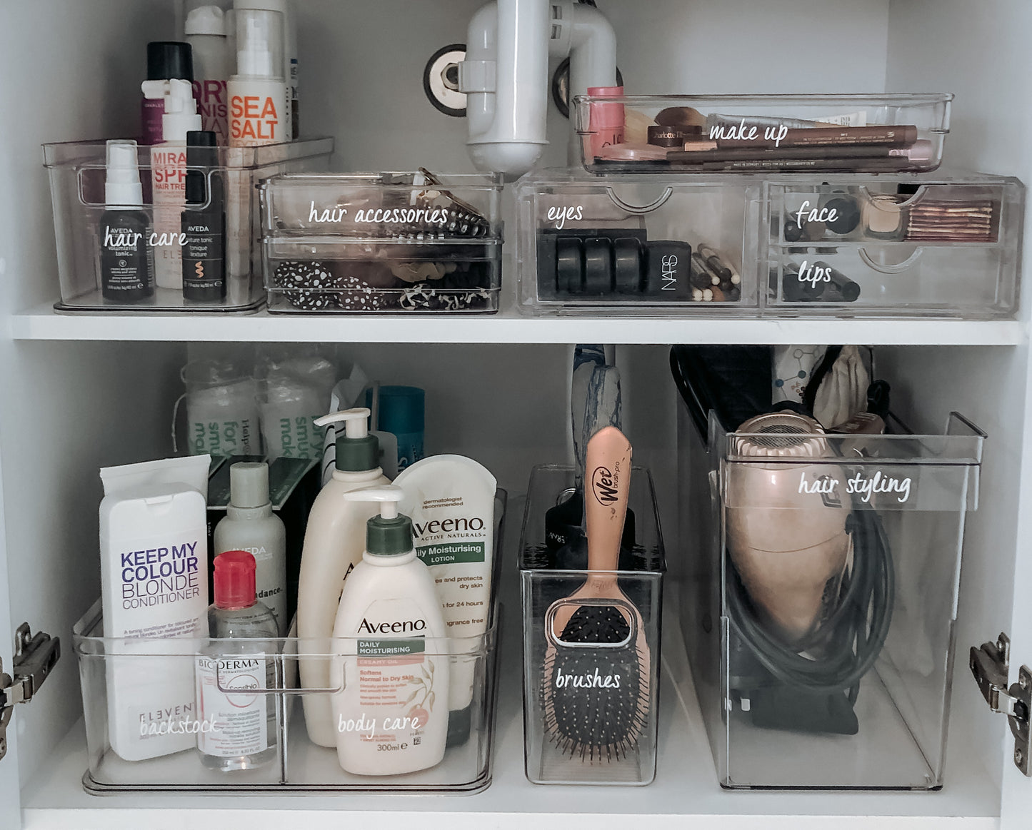 makeup and beauty products in labeled containers in bathroom cupboard